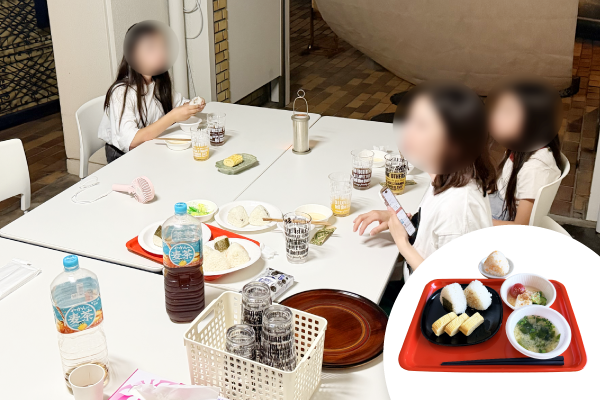 あやめ池子どもガレージ食堂で、親子がおにぎりと味噌汁を食べる様子